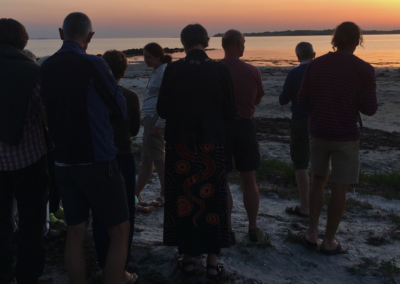 Solnedgang på stranden med mennesker